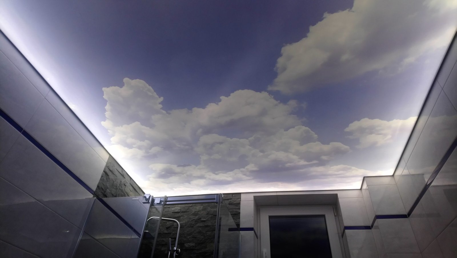 Oryginalne sufity napinane Kraków – fotonadruk z motywem nieba i chmur w łazience z podświetleniem LED.